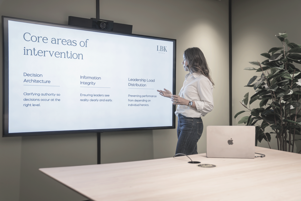 Luciana Breivik presenting the three areas of intervention on a meeting-room screen